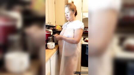 Mulher madura com uma camisa de dormir transparente ao estilo da avó, seios naturais
