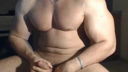 Um homem muito bonito e musculoso a posar e a masturbar-se