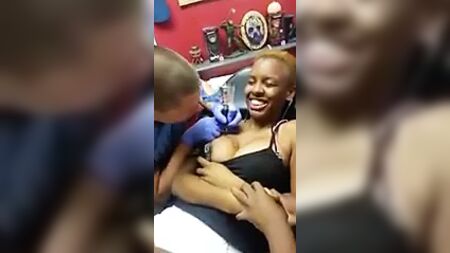 O mamilo salta para fora enquanto se faz uma tatuagem
