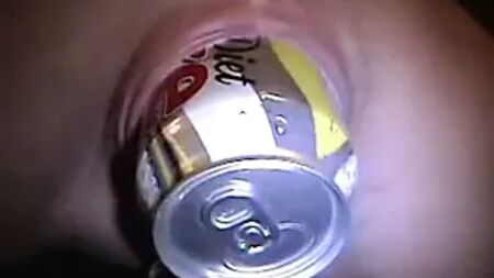 Vagina dilatada e perfurada com uma lata de Coca-Cola dentro Piercings corporais
