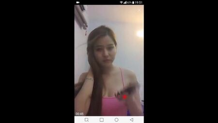 Uma mulher vietnamita aperta os seios e expõe-nos diante da câmara