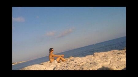 A menina toma banho de sol ao sol completamente nua