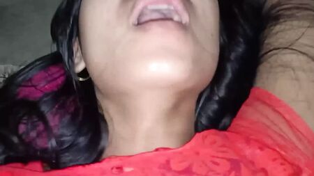 Menina indiana com cabelo curto e encaracolado, de um tom loiro sujo, vestindo um churidar vermelho e usando um lenço na cabeça